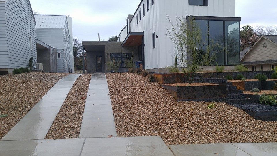 Contemporary home with gravel garden, steel edging and a concrete walkway