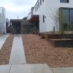 A modern home with a gravel driveway and landscaping.